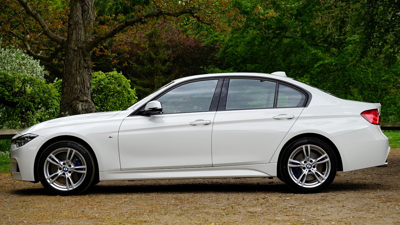 Side view of a sleek white luxury sedan parked outdoors, showcasing elegance and style.